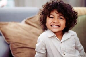 kid boy smiling while playing at home