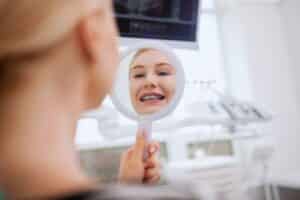 women getting her new braces at orthodontist office to treat teeth shifting