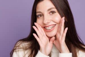 women with braces showing healthy smile